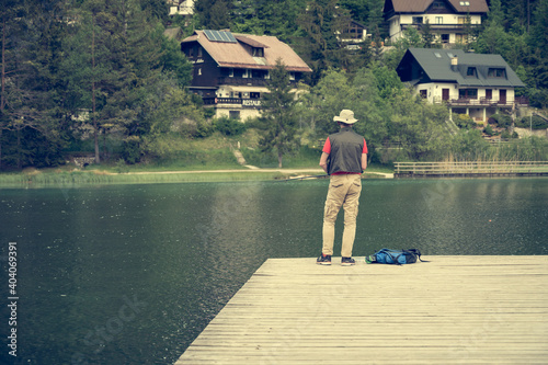 Fisherman standing on wodden pier catching fish.