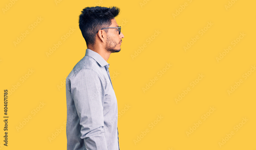 Handsome latin american young man wearing business clothes and glasses looking to side, relax profile pose with natural face with confident smile. Handsome latin american young man wearing business clothes and glasses looking to side, relax profile pose with natural face with confident smile.