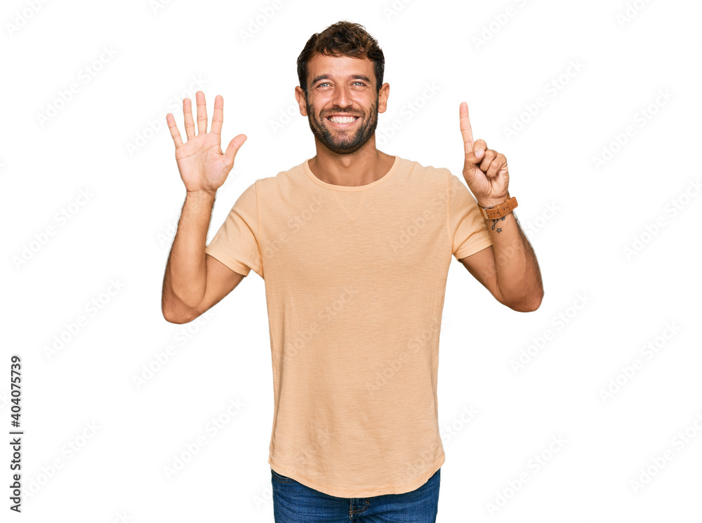 Handsome young man with beard wearing casual tshirt showing and pointing up with fingers number six while smiling confident and happy. Handsome young man with beard wearing casual tshirt showing and pointing up with fingers number six while smiling confident and happy.