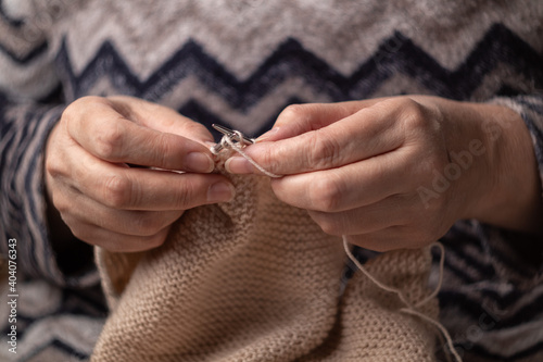woman hands knitting wool yarn with knitting needles