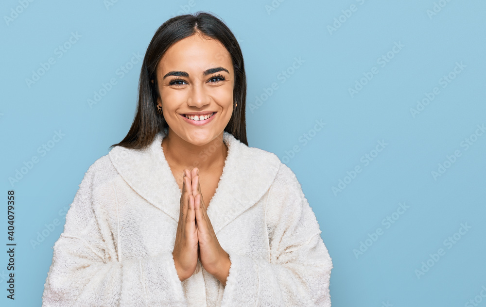 Young brunette woman wearing casual clothes praying with hands together asking for forgiveness smiling confident. Young brunette woman wearing casual clothes praying with hands together asking for forgiveness smiling confident.