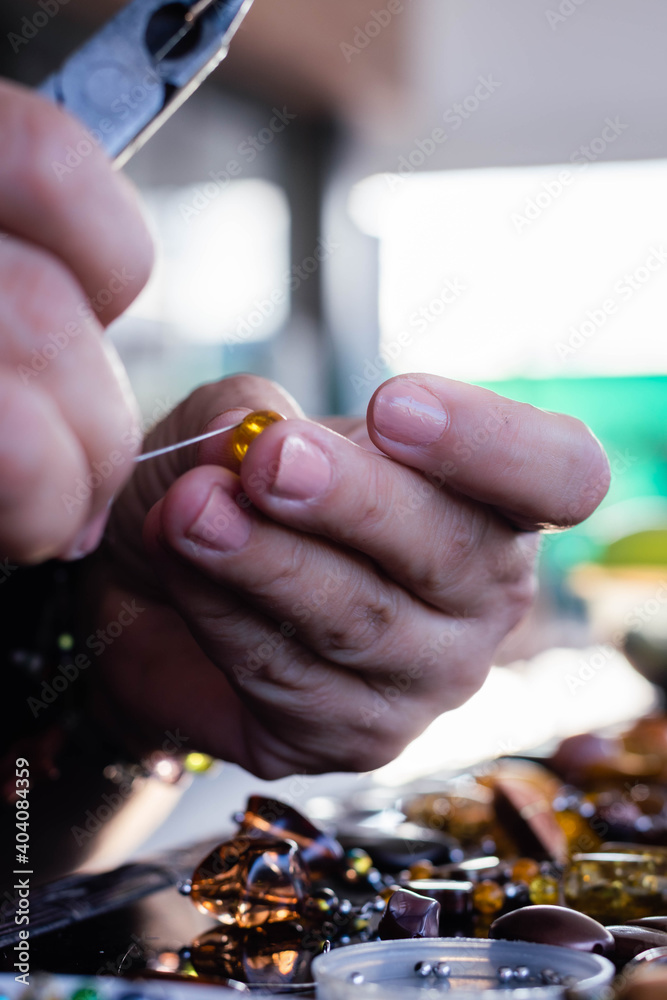 hand of person making stone crafts necklace and metal setting Cordoba Argentina hand of person making stone crafts necklace and metal setting Cordoba Argentina