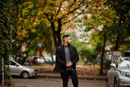 Portrait of stylish arab beard man wear grey turtleneck and black jaket. Arabian model guy on a background of autumn leaves. © AS Photo Family