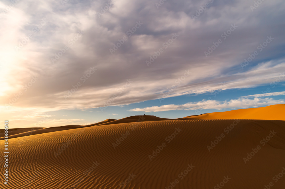 (Selective focus) Stunning view of some sand dunes illuminated at sunset. Merzouga, Morocco. Natural background with copy space.