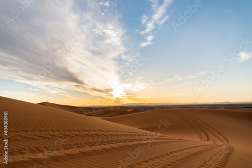 (Selective focus) Stunning view of some sand dunes illuminated at sunset. Merzouga, Morocco. Natural background with copy space.