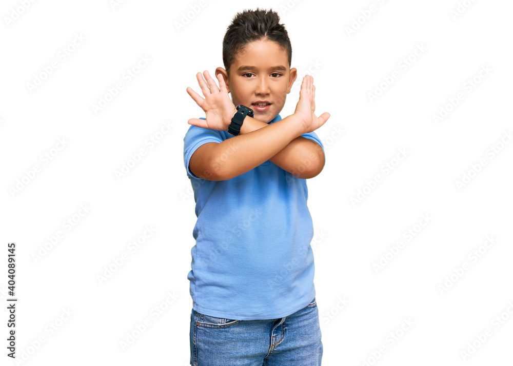 Little boy hispanic kid wearing casual clothes rejection expression crossing arms doing negative sign, angry face Little boy hispanic kid wearing casual clothes rejection expression crossing arms doing negative sign, angry face