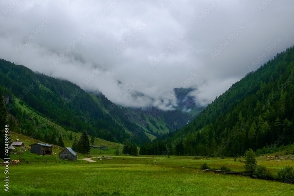 green mountain landscape with houses and dense clouds