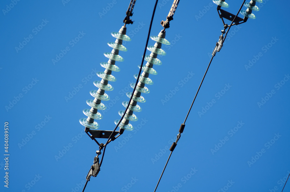 Obraz premium Electric line with insulators against blue sky