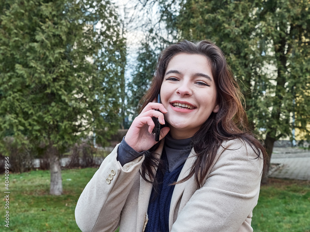 Expression of joyful emotions. The girl speaks on the phone and smiles sincerely. Expression of joyful emotions. The girl speaks on the phone and smiles sincerely.