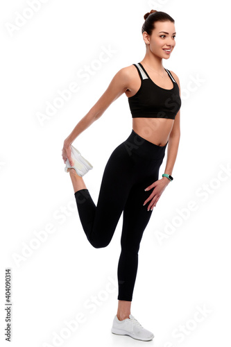 Slim athletic caucasian woman in sport wear doing stretching exercise in white isolated background © khmelev
