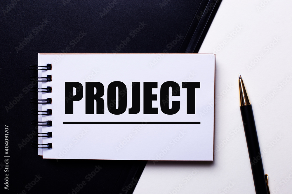 The word PROJECT written in red on a black and white background near the pen The word PROJECT written in red on a black and white background near the pen