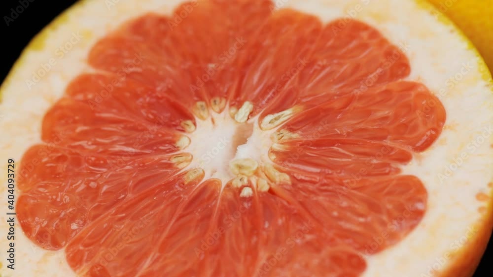 Fresh grapefruits rotating in a circle, black background, and space for text. Cut in half. Fresh grapefruits rotating in a circle, black background, and space for text. Cut in half.