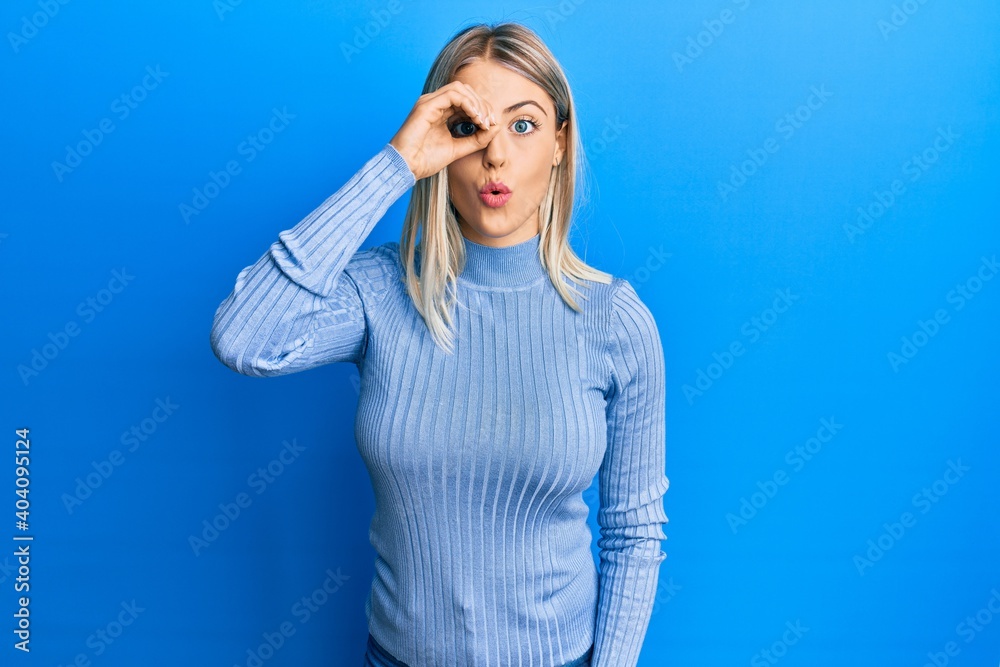 Beautiful blonde woman wearing casual clothes doing ok gesture shocked with surprised face, eye looking through fingers. unbelieving expression. Beautiful blonde woman wearing casual clothes doing ok gesture shocked with surprised face, eye looking through fingers. unbelieving expression.