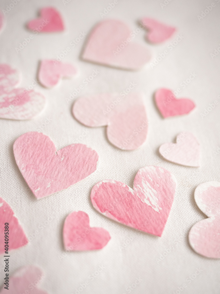 Paper hearts painted in pink watercolor on a white background