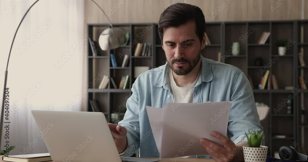 Serious businessman working with document and laptop corporate app sit at workplace desk in office. Focused file clerk prepare report, check make analysis of incoming correspondence, paperwork concept Serious businessman working with document and laptop corporate app sit at workplace desk in office. Focused file clerk prepare report, check make analysis of incoming correspondence, paperwork concept