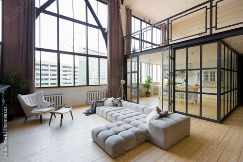 trendy modern design two-level apartment with large high windows. The stylish living room and kitchen in bright colors are undressed by a glass partition. bedroom on the second floor. © 4595886