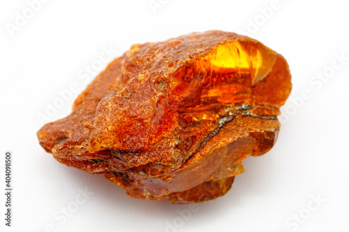 A piece of natural amber on a white background. Fossilized petrified resin. Jewelry material and decoration. Copal. Inclusions in amber. Natural peel. Sun stone
