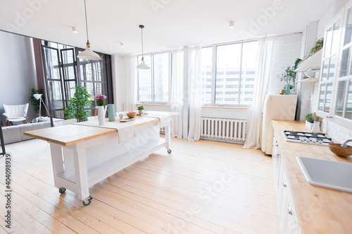 Fototapeta Naklejka Na Ścianę i Meble -  trendy modern design two-level apartment with large high windows. The stylish living room and kitchen in bright colors are undressed by a glass partition. bedroom on the second floor.