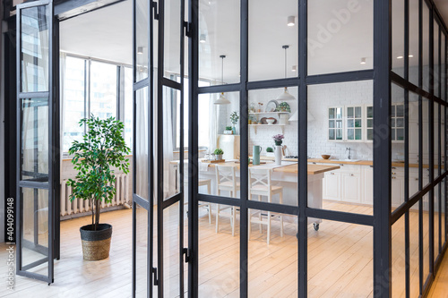 trendy modern design two-level apartment with large high windows. The stylish living room and kitchen in bright colors are undressed by a glass partition. bedroom on the second floor.