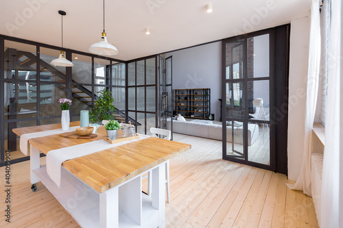 trendy modern design two-level apartment with large high windows. The stylish living room and kitchen in bright colors are undressed by a glass partition. bedroom on the second floor.