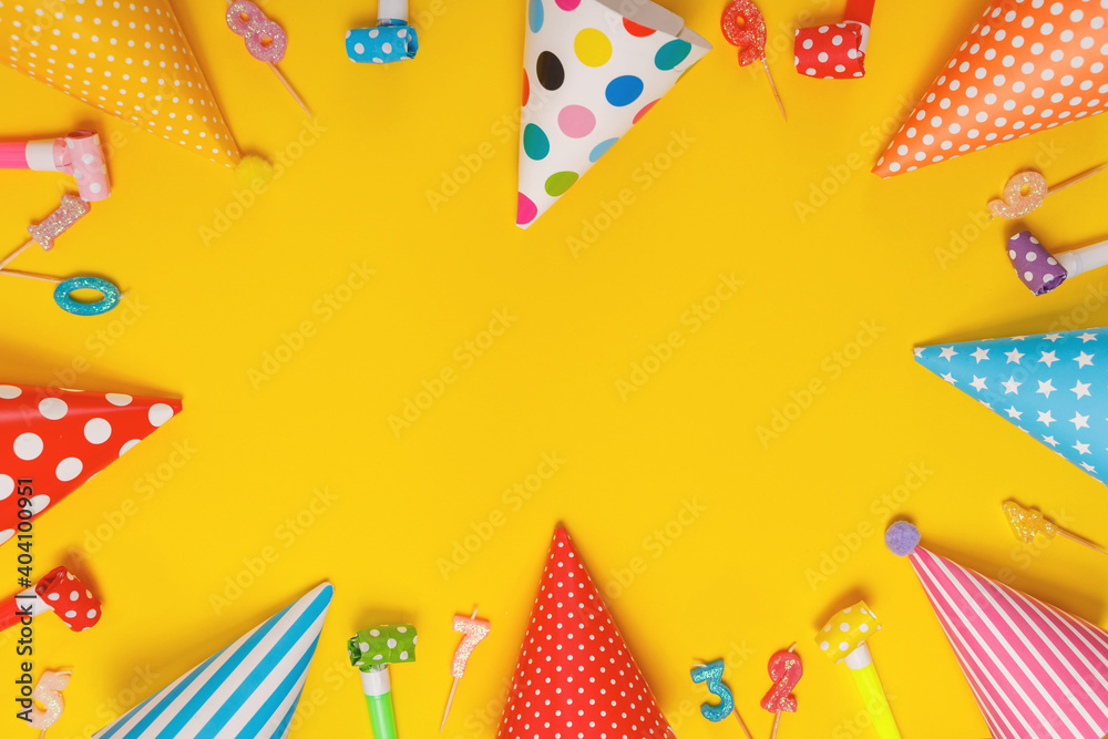Colored party hat and candles lying on yellow background. Colored party hat and candles lying on yellow background.