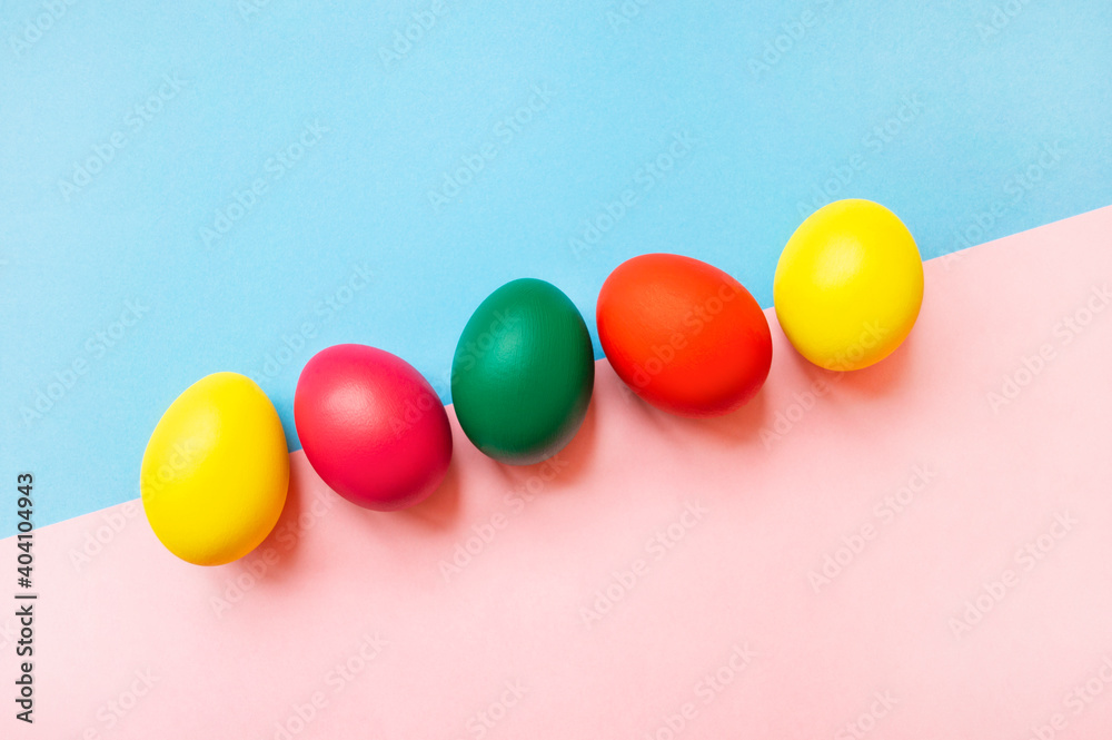 colorful easter eggs on pink and blue background with copy space. Easter background colorful easter eggs on pink and blue background with copy space. Easter background