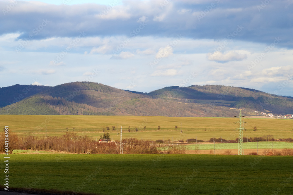 Fototapeta premium Autumn landscape. Bright sunny day. Yellow, orange, green field on the background of picturesque hills and sky. Wallpaper.