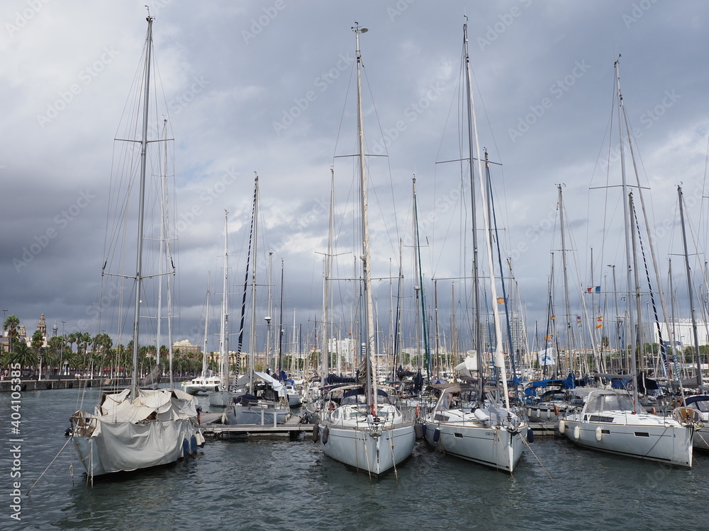 BARCELONA, SPAIN on SEPTEMBER 2019: View to luxury yachts in port of european city at Catalonia district, cloudy sky in cold summer day.