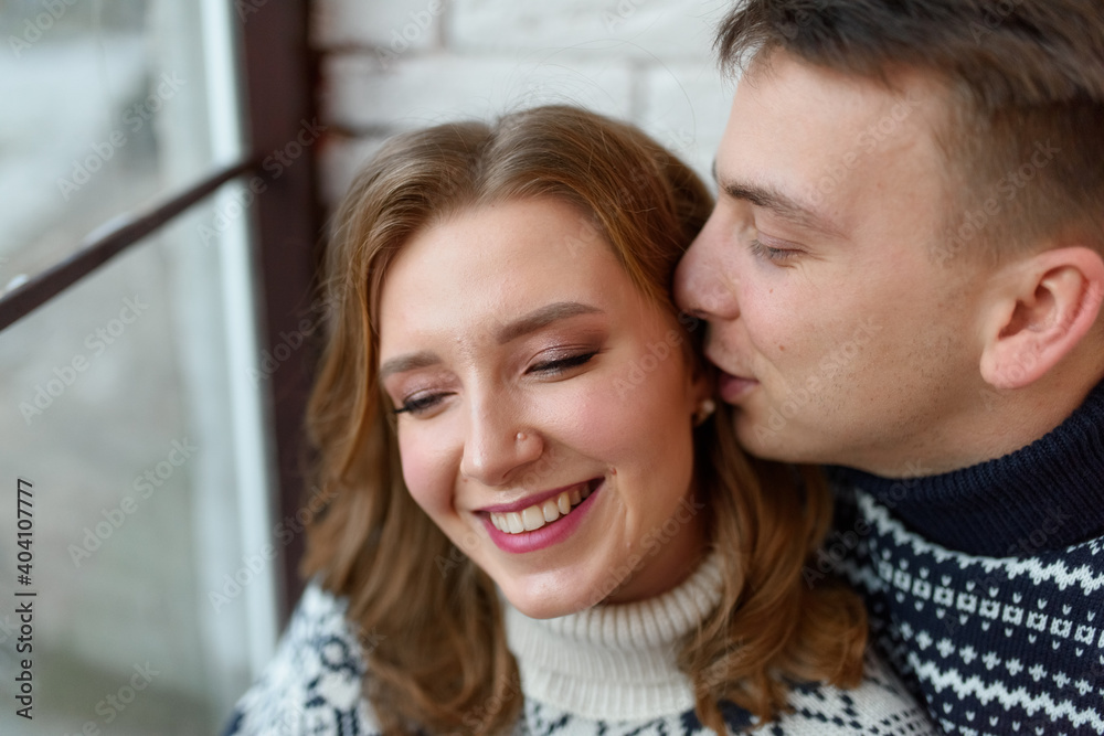 Image of young happy man kissing and hugging beautiful woman Image of young happy man kissing and hugging beautiful woman