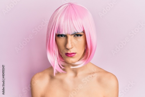 Young man wearing woman make up wearing pink wig skeptic and nervous, frowning upset because of problem. negative person.