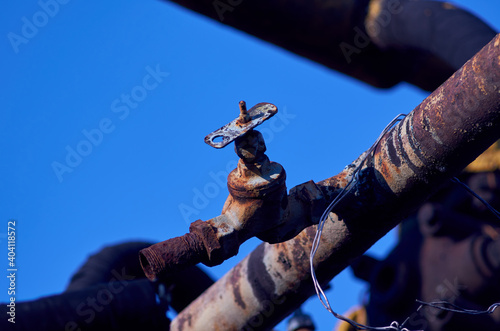 Rusty water tap on blue sky background