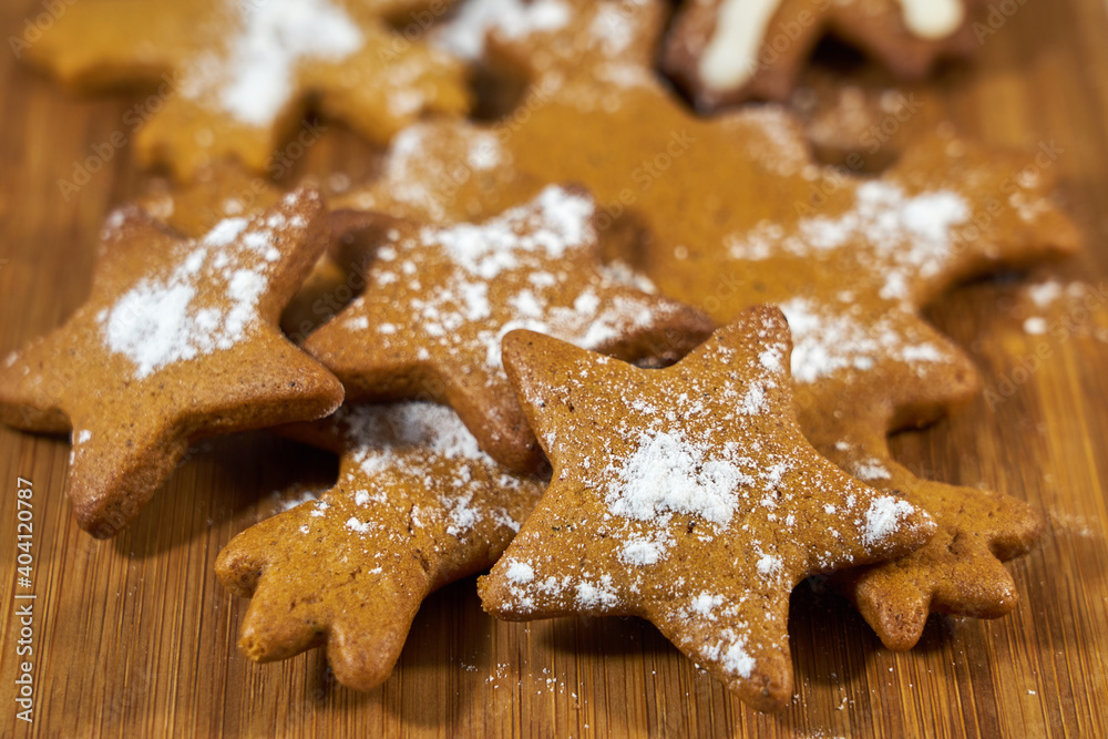 Ginger biscuits with sugar powder on a wooden board. Ginger biscuits with sugar powder on a wooden board.