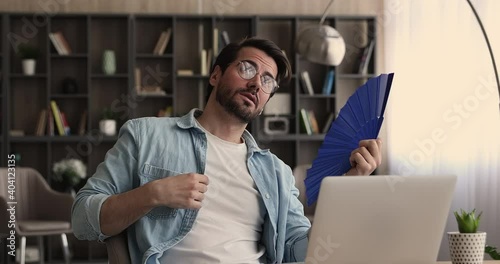 Wallpaper Mural Businessman in glasses sit at desk suffering from heat at workplace waving blue handheld fan reducing too high temperature indoors, man feels unwell, sick discomfort in office without air conditioner Torontodigital.ca