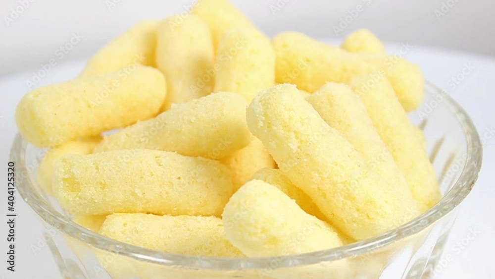 Sweet corn sticks in a glass plate on a white background. Turntable. Selective focus. Sweet corn sticks in a glass plate on a white background. Turntable. Selective focus.