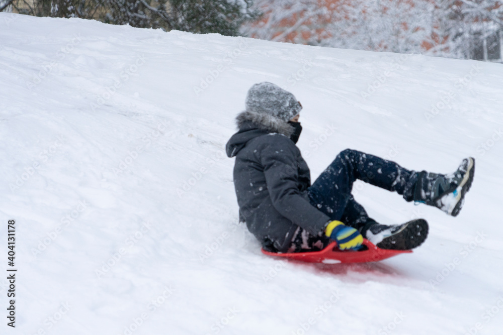 Boy enjoying a sleigh ride. Kid playing outdoors in snow Boy enjoying a sleigh ride. Kid playing outdoors in snow