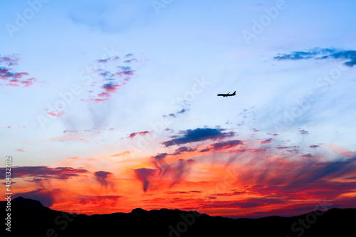 Red clouds at sunset and a passenger plane