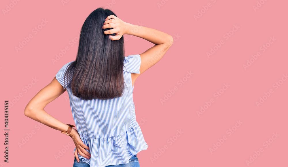 Young beautiful latin girl wearing casual clothes backwards thinking about doubt with hand on head Young beautiful latin girl wearing casual clothes backwards thinking about doubt with hand on head