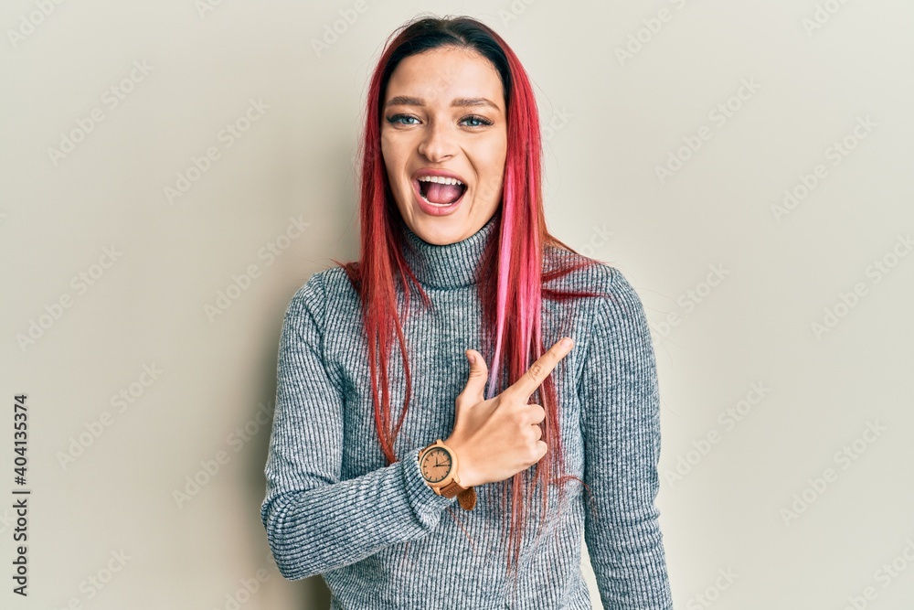 Young caucasian woman wearing casual clothes cheerful with a smile of face pointing with hand and finger up to the side with happy and natural expression on face Young caucasian woman wearing casual clothes cheerful with a smile of face pointing with hand and finger up to the side with happy and natural expression on face