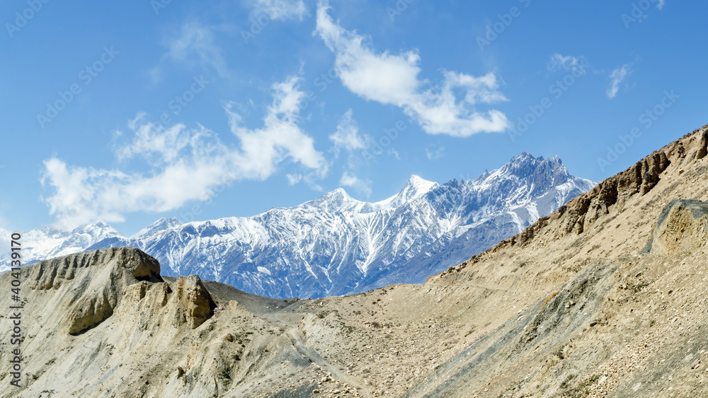 Barren landscape and snow-capped mountains on the trail from Muktinath to Kagbeni, Annapurna Circuit, Nepal