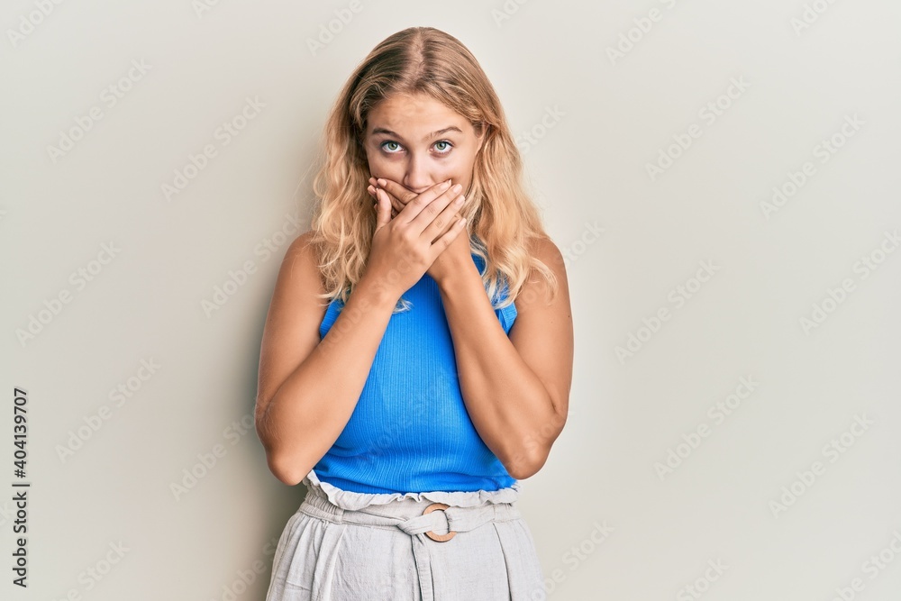 Young blonde girl wearing casual clothes shocked covering mouth with hands for mistake. secret concept. Young blonde girl wearing casual clothes shocked covering mouth with hands for mistake. secret concept.