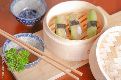 Salmon sushi typical of Japanese cuisine on black plate, natural light inside restaurant