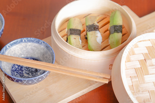 Salmon sushi typical of Japanese cuisine on black plate, natural light inside restaurant