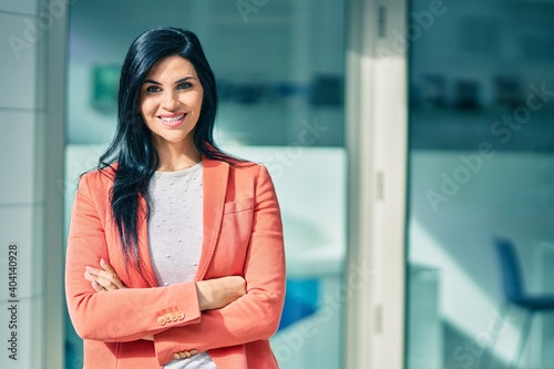 Young beautiful businesswoman with crossed arms smiling happy standing at the city. Free Download Young beautiful businesswoman with crossed arms smiling happy standing at the city. - GFXLoad