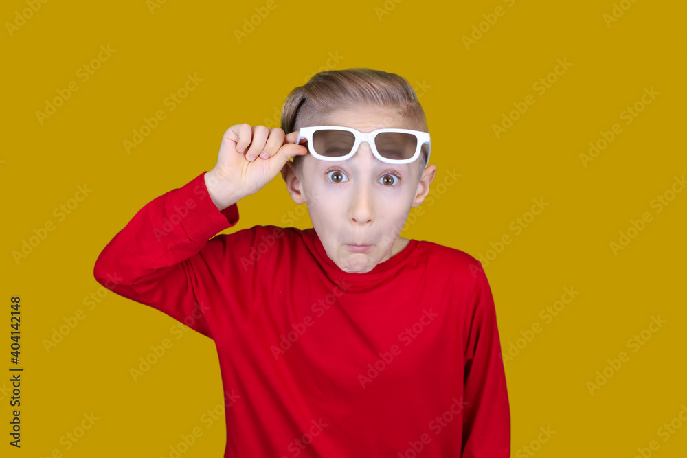 the child pulls on the forehead of children's 3D glasses and makes funny faces the child pulls on the forehead of children's 3D glasses and makes funny faces