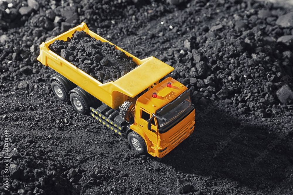 Toy tipper truck with coal in field Toy tipper truck with coal in field