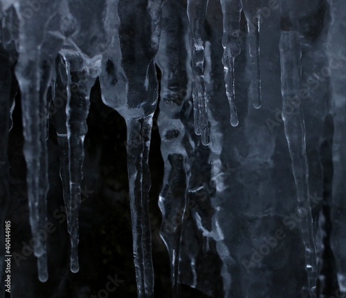 Macro Icicles in nature hanging in front of dark background