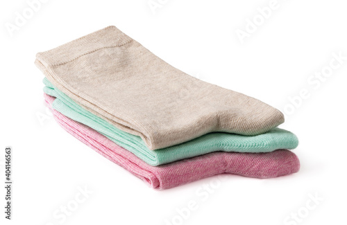 Stack of new tall colorful socks isolated on a white background. Three pairs of beige, green and pink socks folded in half. Elastic cotton hosiery. Full depth of field.