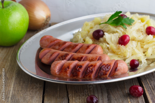 Stewed fermented cabbage with roasted sausages. Close up