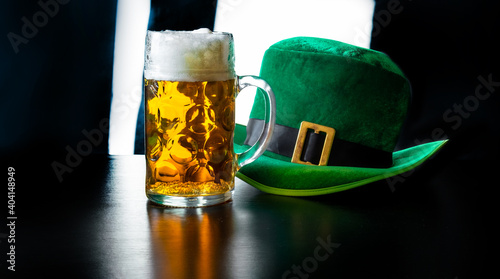 St Patrick's day glass beer hand hold costume hat leprechaun black background