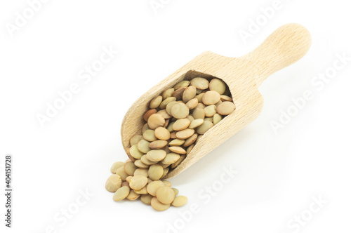 Uncooked raw green lentil in wooden shovel isolated on white background, (Lens culinaris)